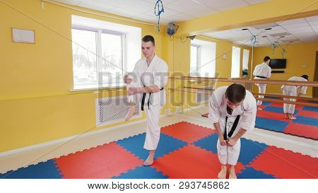 Two Athletic Men Training Their Aikido Skills In The Studio. Warming Up Before Training