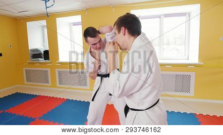 Two Athletic Men Training Their Aikido Skills In The Studio. Protecting