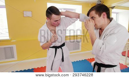 Two Athletic Men Training Their Aikido Skills In The Studio. Protecting From The Hit