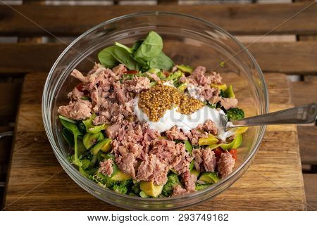 Tune Ceaser Salad On Black Plate On Wooden Table.