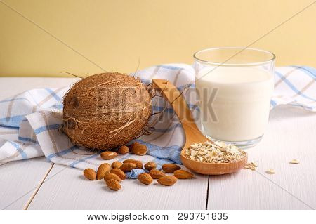 Assortment Of Organic Vegan Non Dairy Milk From Nuts In Glass On A Wooden Table On Yellow Background