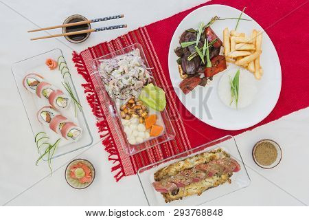 Sushi Nikkei, Lomo Saltado, Tuna, Ceviche And Soy Sauce On A White Table