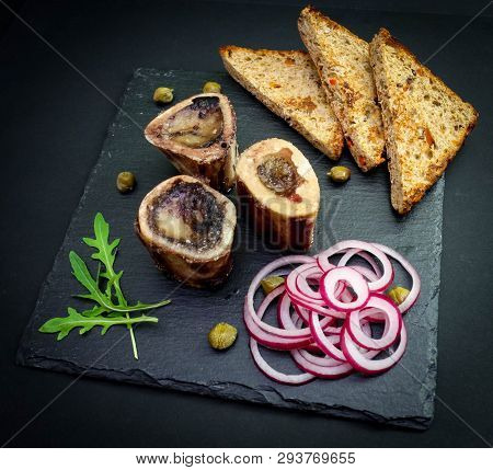 Close-up Of Rustic English Bone Marrow With Toast, Capers And Onions