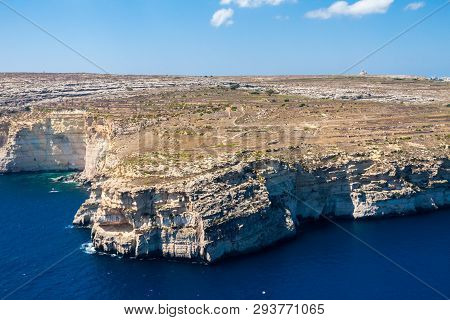 Cliffs And Blue Lagoons Of Gozo Island Seen From Above. Aerial View Of Gozo, Malta. The Rotunda Of X