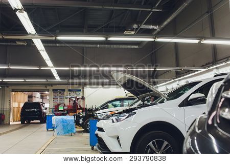 Black Car Repair Station With Soft-focus In The Background And Over Light.