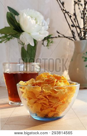 A Mug Of Tea, A Cup Of Corn And A Cake On A Sunny Table, A Bouquet Of Spring Flowers For Mood, Diet 