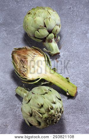 Artichokes On Rustic Background. Fresh Organic Artichoke Flower Set