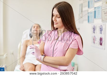 Young Dark Haired Attractive Doctor Dressed Pink Gown And Latex Gloves With Syringes In Her Hand. Do