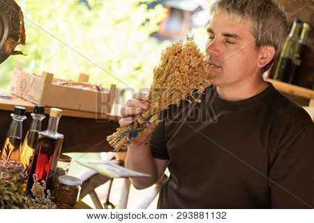 herbalist gardender  small business owner picking gathering fresh herbs for alternative medicine tea and poutting on balance