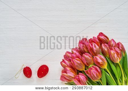 Easter Background. Deorative Easter Eggs And Pink Tulips On White Background. Copy Space, Top View.