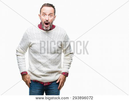 Middle age hoary senior man wearing winter sweater over isolated background afraid and shocked with surprise expression, fear and excited face.
