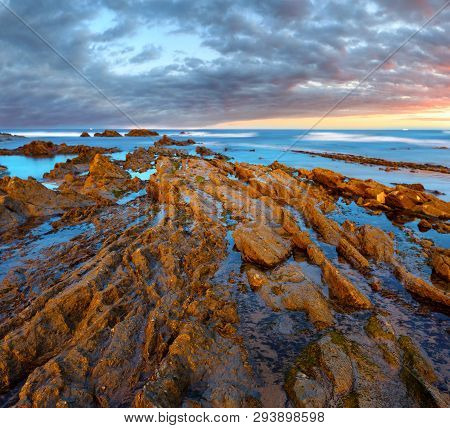Twilight Ocean Coast With Ribbed Stratiform Rock Formations, Atlantic Ocean, Spain.