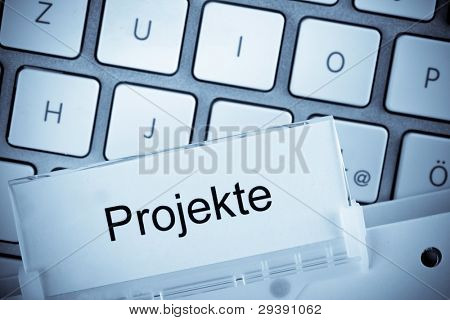 jeden závěsné složky kartu před klávesnice počítače na projektech