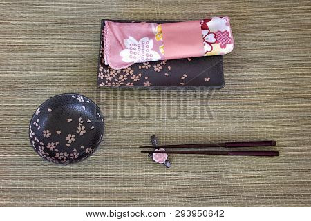 Sushi Set.two Wooden Chopsticks, Small Black Bowl Served On Wooden Background. Asian Traditional Bam