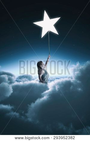 Woman Rising Up Above The Clouds Holding A Star.