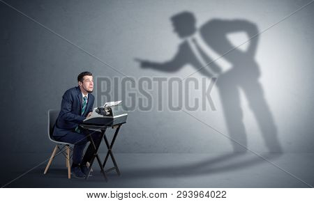 Little man working and a big shadow arguing with him