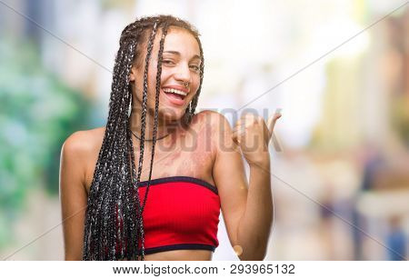 Young braided hair african american with pigmentation blemish birth mark over isolated background doing happy thumbs up gesture with hand. Approving expression looking at the camera 