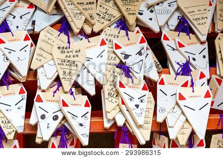 Kyoto, Japan - 14 June 2016: Prayers to the Fox God, or Kitsune, Fushimi Inari Shrine, Kyoto, Japan