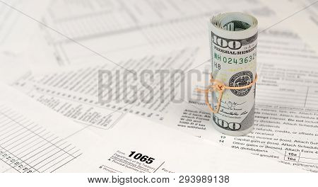 1065 U.s. Return Of Parentship Income Form With Roll Of American Dollar Banknotes