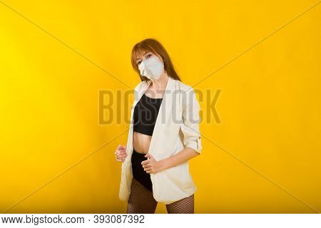 Female Strip Dancer In Yellow Studio In Protective Mask From Covid