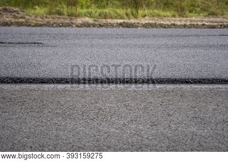 A Large Layer Of Fresh Hot Asphalt. Layer Of Asphalt Raw Material In A Shallow Depth Of Field. Rolle