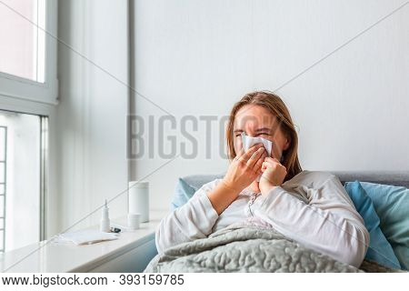 Sick Woman Blowing Her Nose With Headache And Fever Lying Under The Blanket. Sick Woman Staying In B