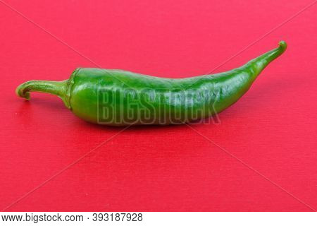 Green C Hili Paprika, On A Red Background. Healthy Food. Fresh Vegetables . Green Chili Peppers On A
