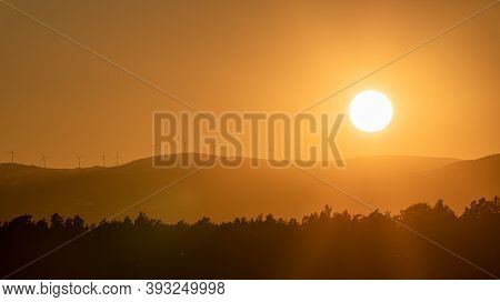 Dramatic Silhouette Sunset Over Lavanttaler Alps In Styria. Styrian Alps Covered With Snow In Orange