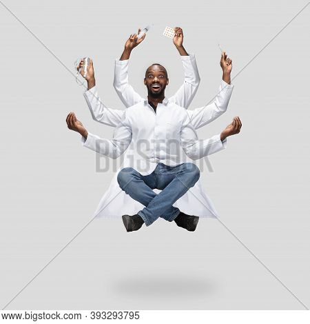 Handsome African Doctor, Multi-armed Man Levitating Isolated On Grey Studio Background With Equipmen