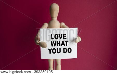 The Wooden Man Holds A White Sign With The Text Love What You Do In His Hands. The Content Of The Le