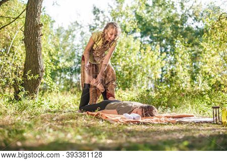 Massage Trainer Thuroughly Massages A Girl On The Grass.