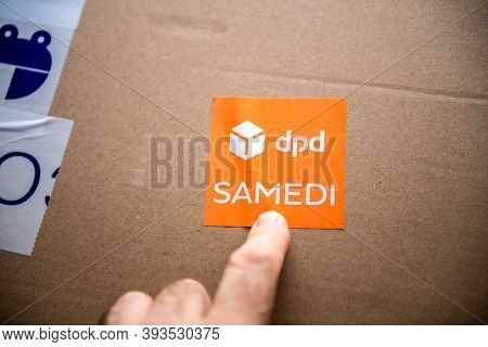Paris, France - Oct 14, 2020: Pov Male Hand Pointing At The Cardboard Parcel Box Sticker Featuring D