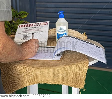 Proserpine, Queensland, Australia - October 2020: Man Signs Into Restaurant Under Conditions Of Entr
