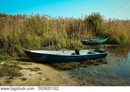 Boats Are Tied With A Chain Standing In The Water With Mud. Leningrad Region. Russia. September 2020