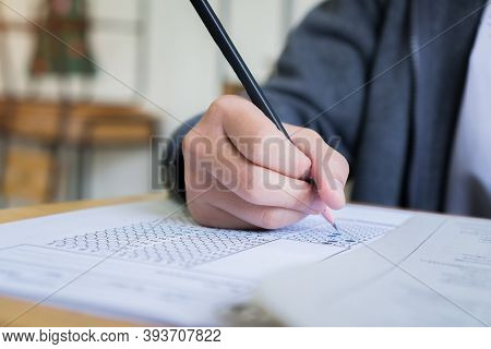 Hand Student Use Pencil Writing On Paper Optical Form Of Standardized Test Examination, Answer Sheet