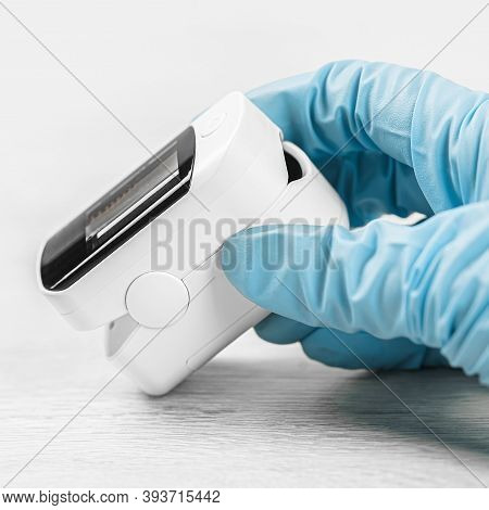 Medical Concept. Pulse Oximeter In Hand. Medical Protective Glove. Pneumonia, Covid Prevention And C
