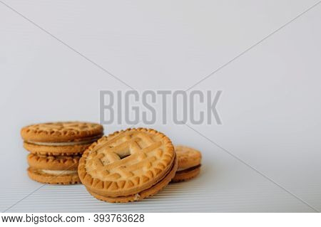Broken Cookies With Crumbs Lies On A Brown Table On A White Background