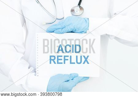 Doctor Holds A Card With The Name Of The Diagnosis Acid Reflux.medical Concept.