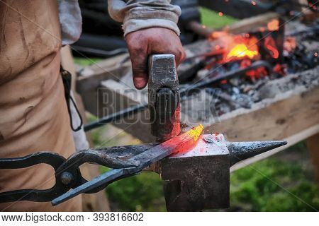 Twisting A Red-hot Billet Is Clamped In The Grip. Blacksmith Twists A Hot Rod On The Anvil., Lifesty