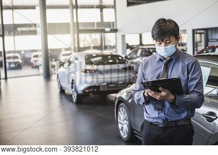 Asian Saleman Wear Surgical Mask Working In Inspector Checking Writing On Clipboard In Garage Of Dea