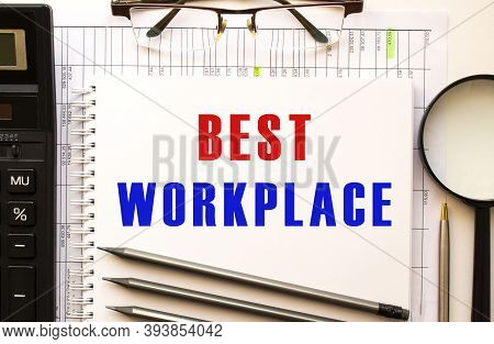 Office Desk With Financial Papers, Calculator, Glasses. Notepad Page With The Text Best Workplase.