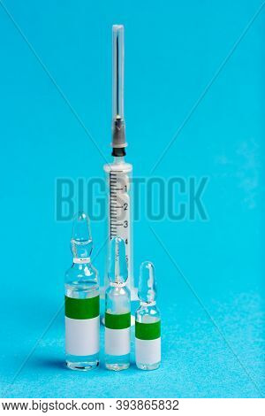 Syringe And Three Ampoules With Vitamins Or Vaccine. Medical Topics. Vaccine For Chovid-19