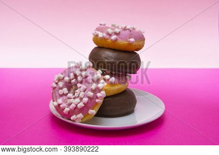 Close-up Of A White Plate Of Pink Donuts With Cumin And Chocolate Covered. Horizontal Photography