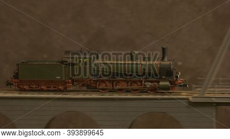 Side View Lokomotive Train On The Bridge. Replica Of Retro Train Model On A Railway Station.