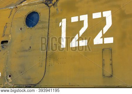 Camouflage Side Of Old Military Equipment With A Closed Massive Door With A Round Window And Number 