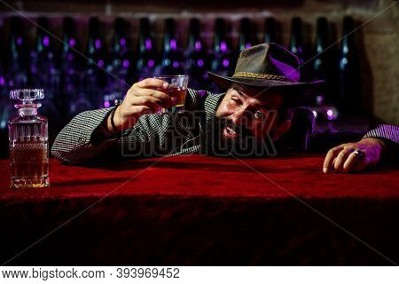 After Drinking In Pub Or Bar. Sleepy Drunk Young Man Lying On Table And Sleeping With Empty Bottles