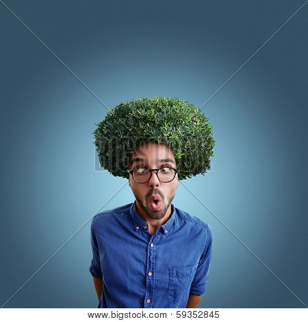 Young cross-eyed man with green bush instead hair