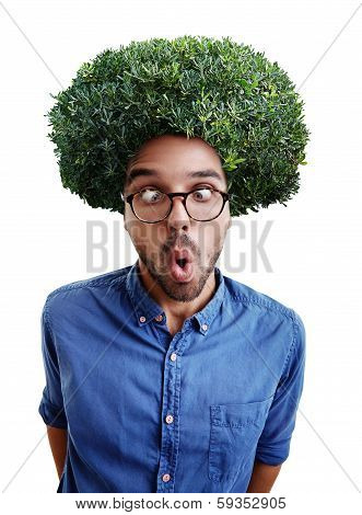 Young cross-eyed man with green bush instead hair