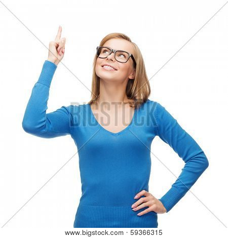 advertisement concept - attractive young woman in casual clothes and black eyeglasses pointing her finger up