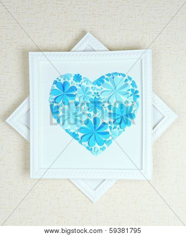 Beautiful handmade picture with heart from paper flowers on wall